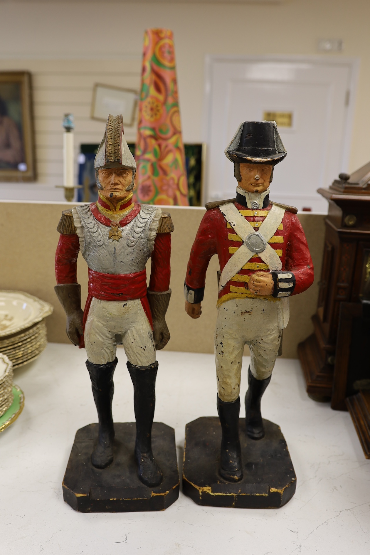 A pair of painted figures of soldiers in military dress, 49cm high. Condition - fair